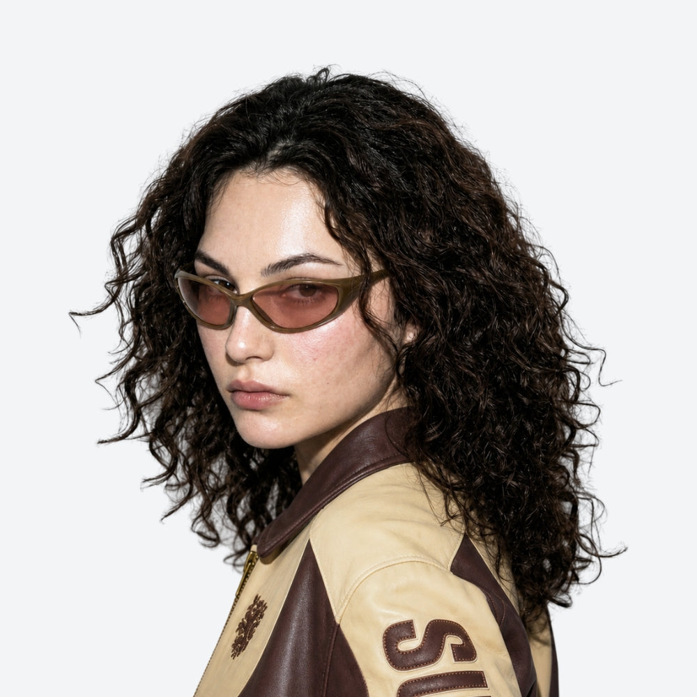 Woman wearing VYSER Brown sunglasses with brown-tinted lenses on a white background