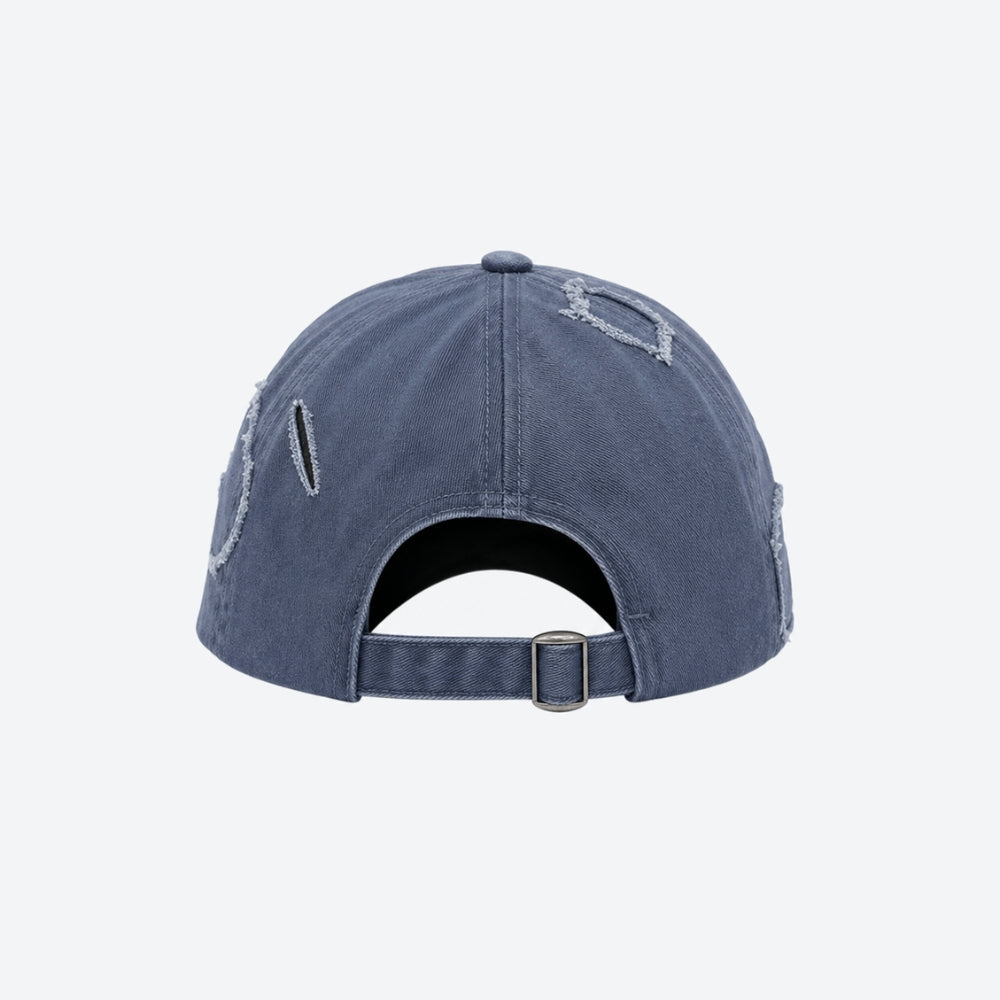 A washed blue denim baseball cap shown from the back, featuring distressed details and a metal buckle closure, on a light gray background.