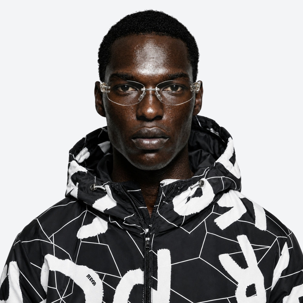 Person wearing a black and white patterned jacket with a VYSER Black with transparent lens a white background