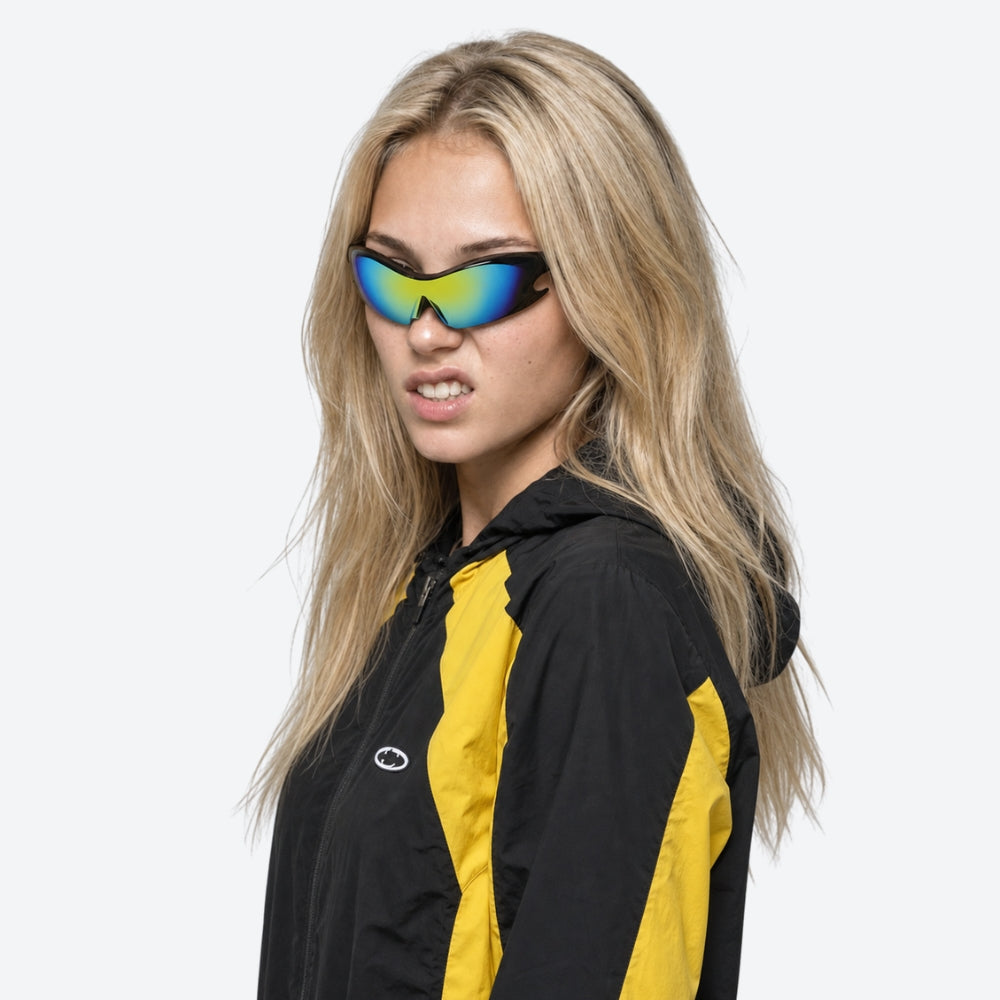 Woman wearing a black and yellow jacket with VYSER Sunglasses with reflective blue and green lenses on a white background