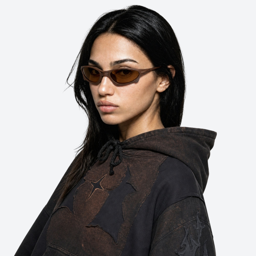 Person wearing a dark hoodie with VYSER Brown sunglasses with brown lenses on a white background