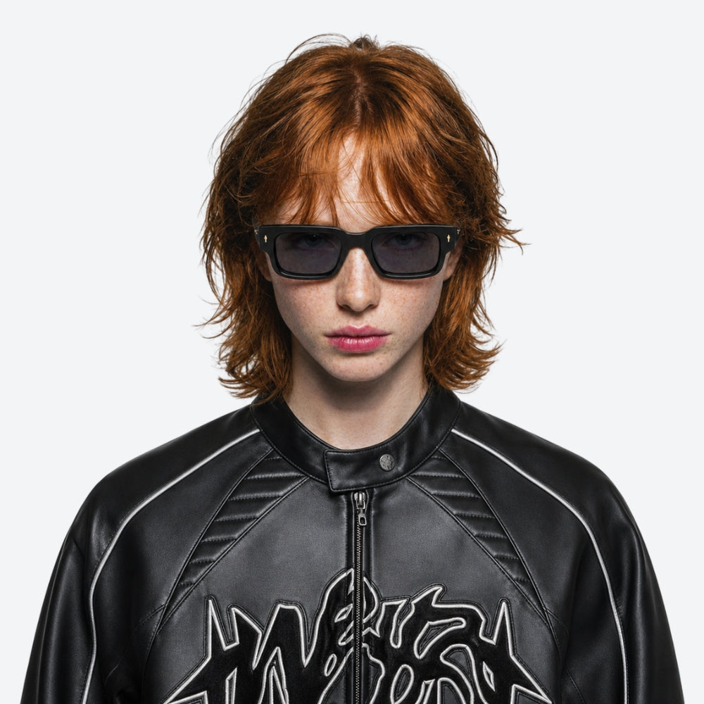 Person wearing a black leather jacket and a VYSER Black sunglasses with dark lenses on a white background
