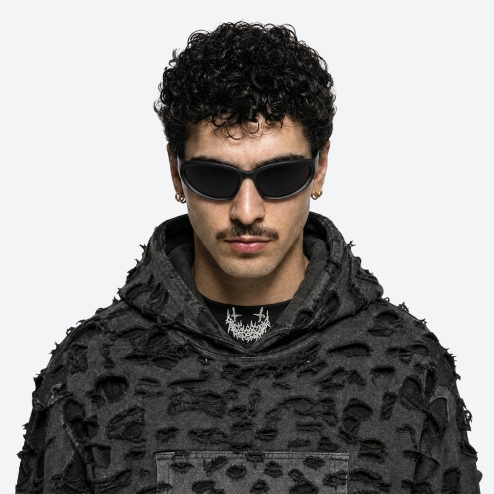 Person wearing a black textured hoodie and VYSER Black sunglasses with dark lenses on a white background