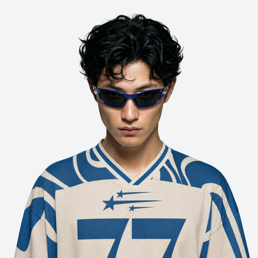Person wearing a blue and white sports jersey with VYSER Blue sunglasses with silver STAR accents on a white background