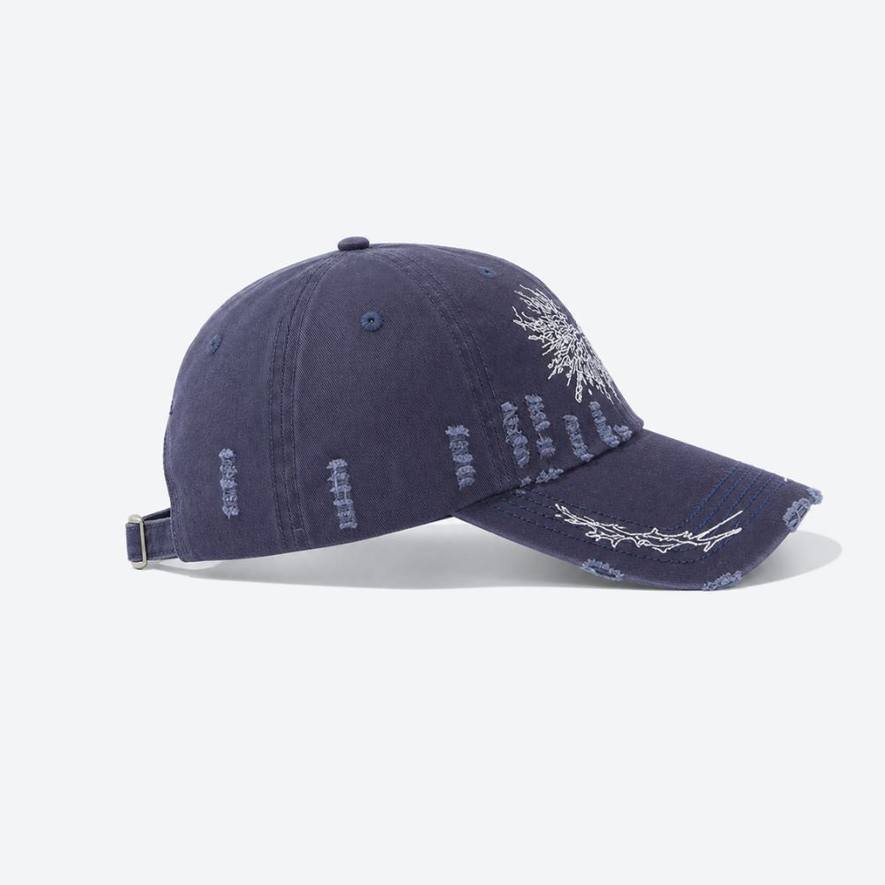 Side profile of a navy blue distressed baseball cap showing the embroidered thorn branch running along the brim