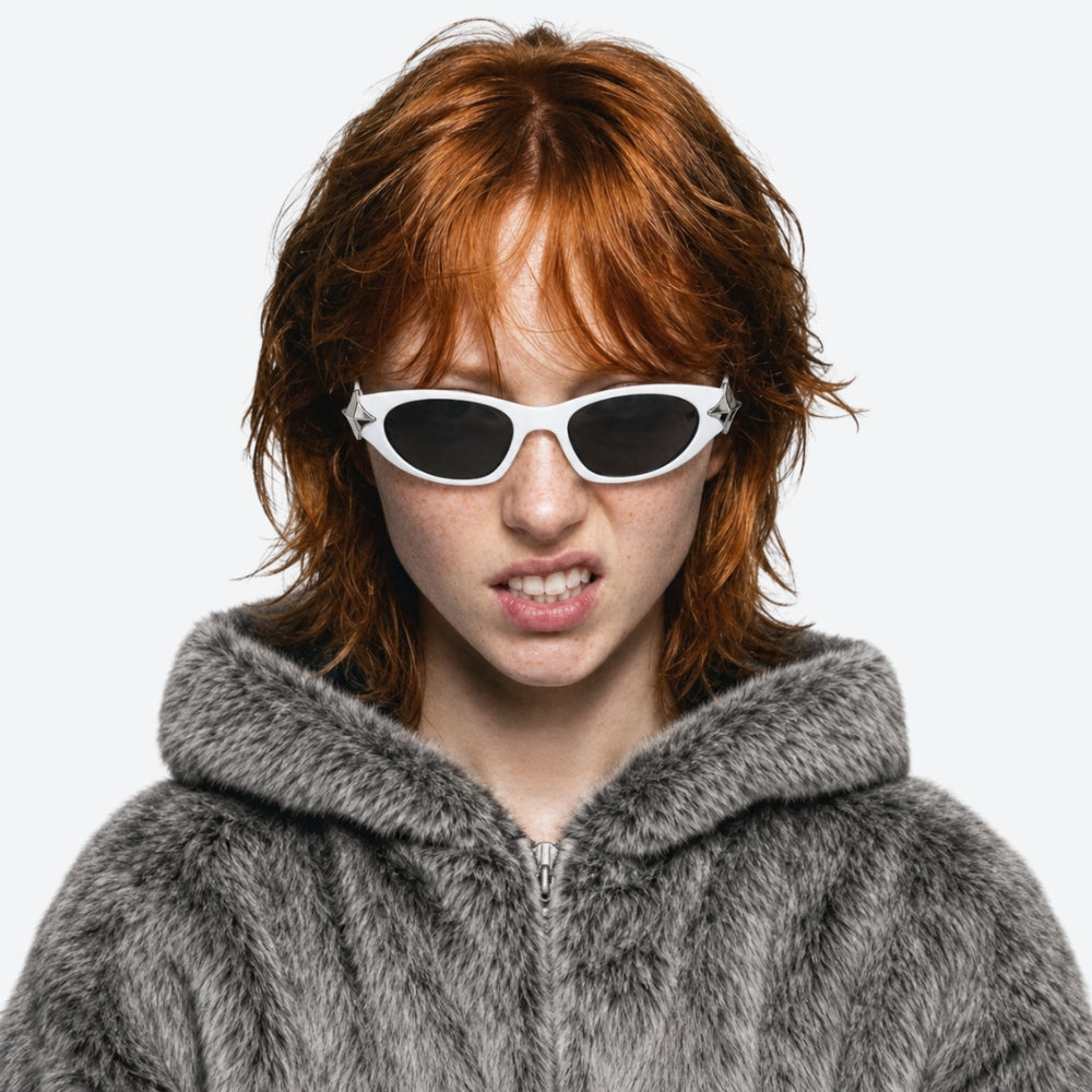 Person with red hair wearing VYSER WHITE sunglasses with silver STAR accents on a white background