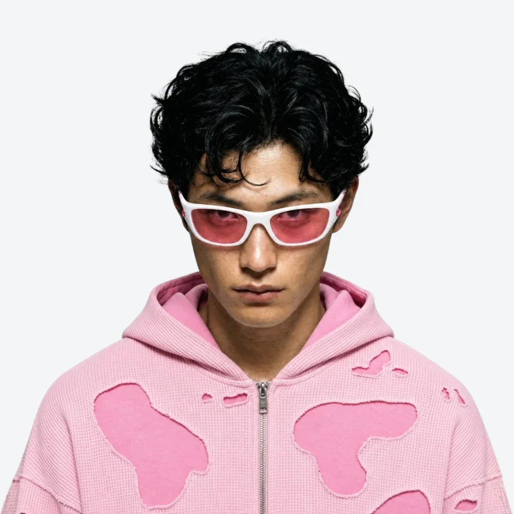Person wearing a pink hoodie with butterfly designs and VYSER white and pink sporty sunglasses with translucent arms, modern streetwear style.