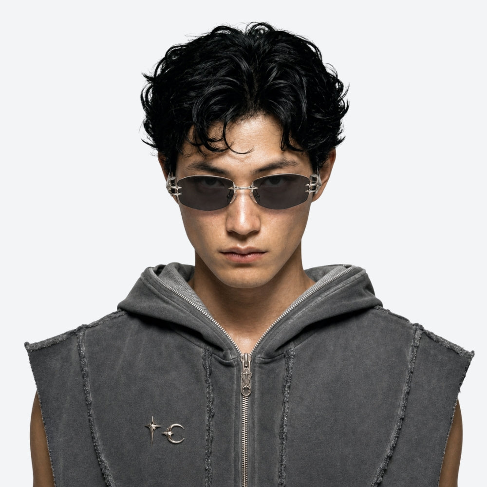 Person wearing a gray sleeveless jacket with VYSER Sunglasses with black frames and dark lenses on a white background