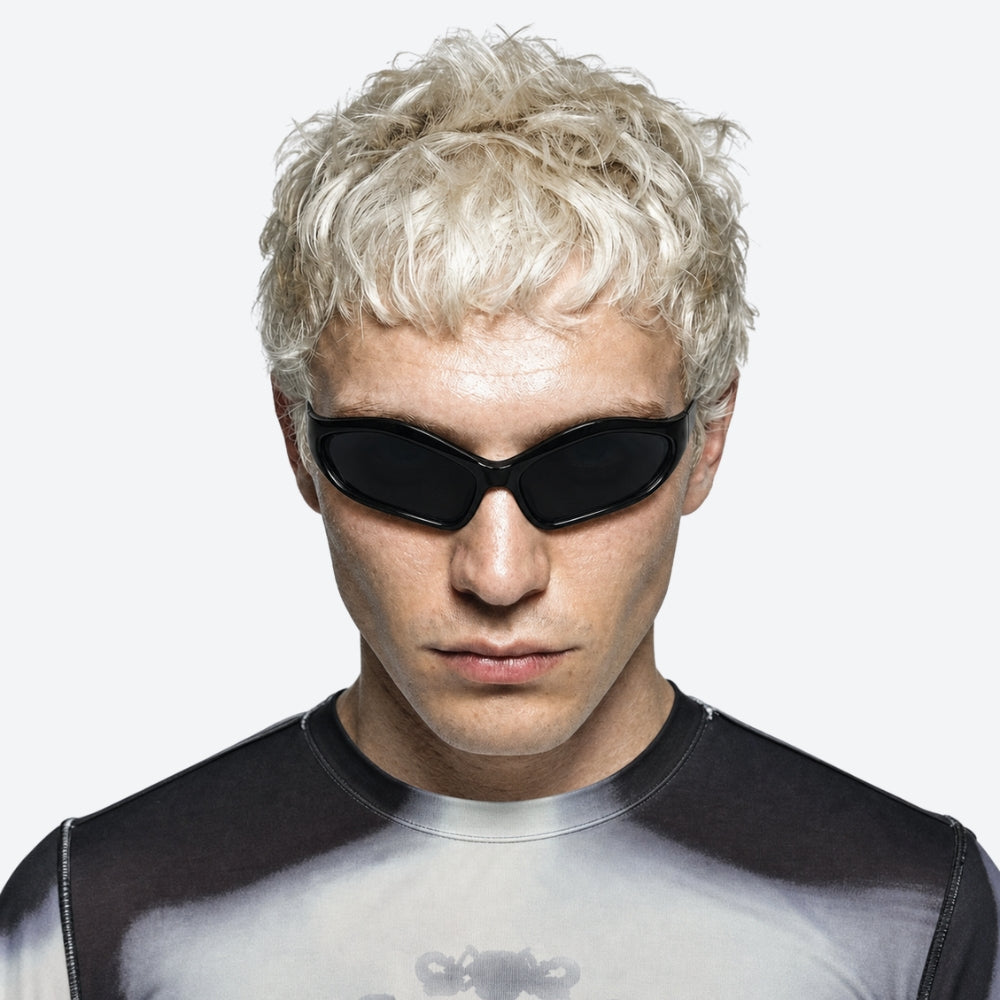 Person with blonde hair wearing VYSER dark sunglasses against a white background