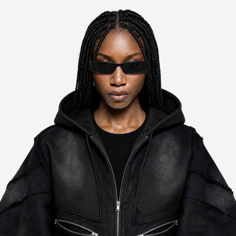 Person wearing a black jacket and VYSER Black sunglasses on a white background