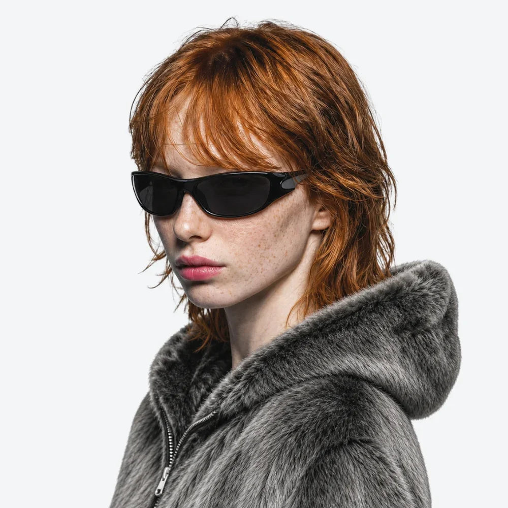 VYSER black sleek cat-eye sunglasses paired with gray faux fur hooded jacket, streetwear style.