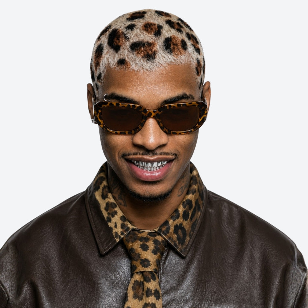 Man wearing a VYSER Sunglasses with leopard print frame and brown lenses on a white background