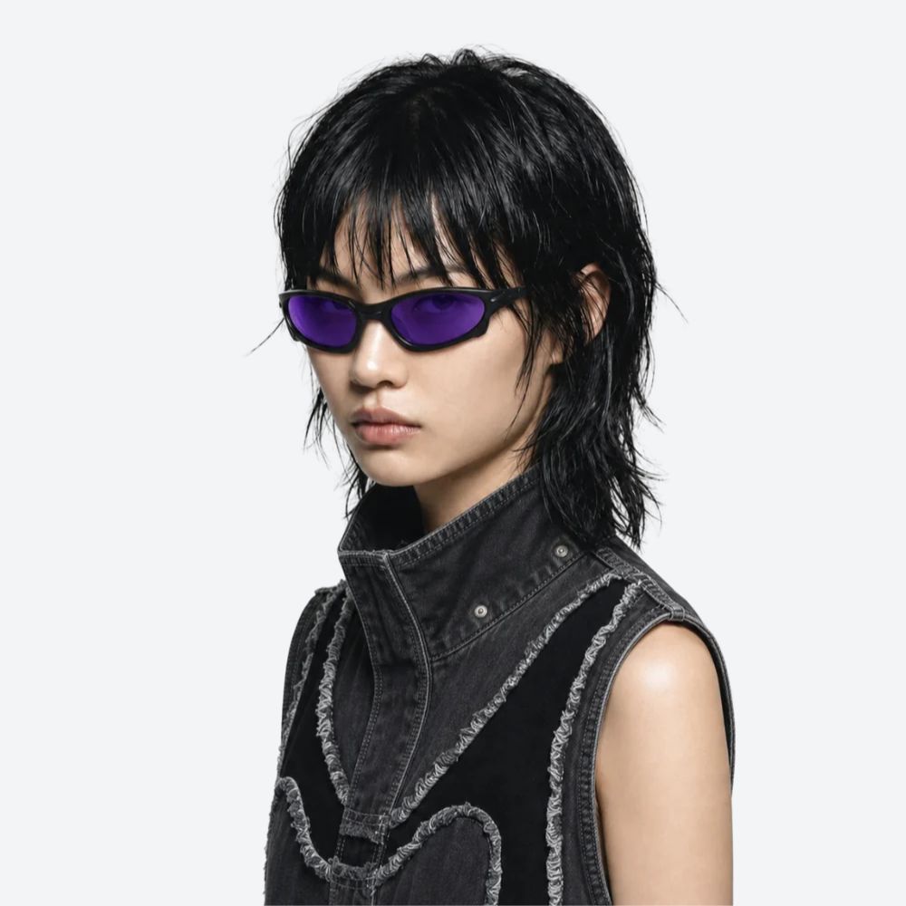 Person wearing VYSER Sunglasses with a black frame and purple lenses on a white background