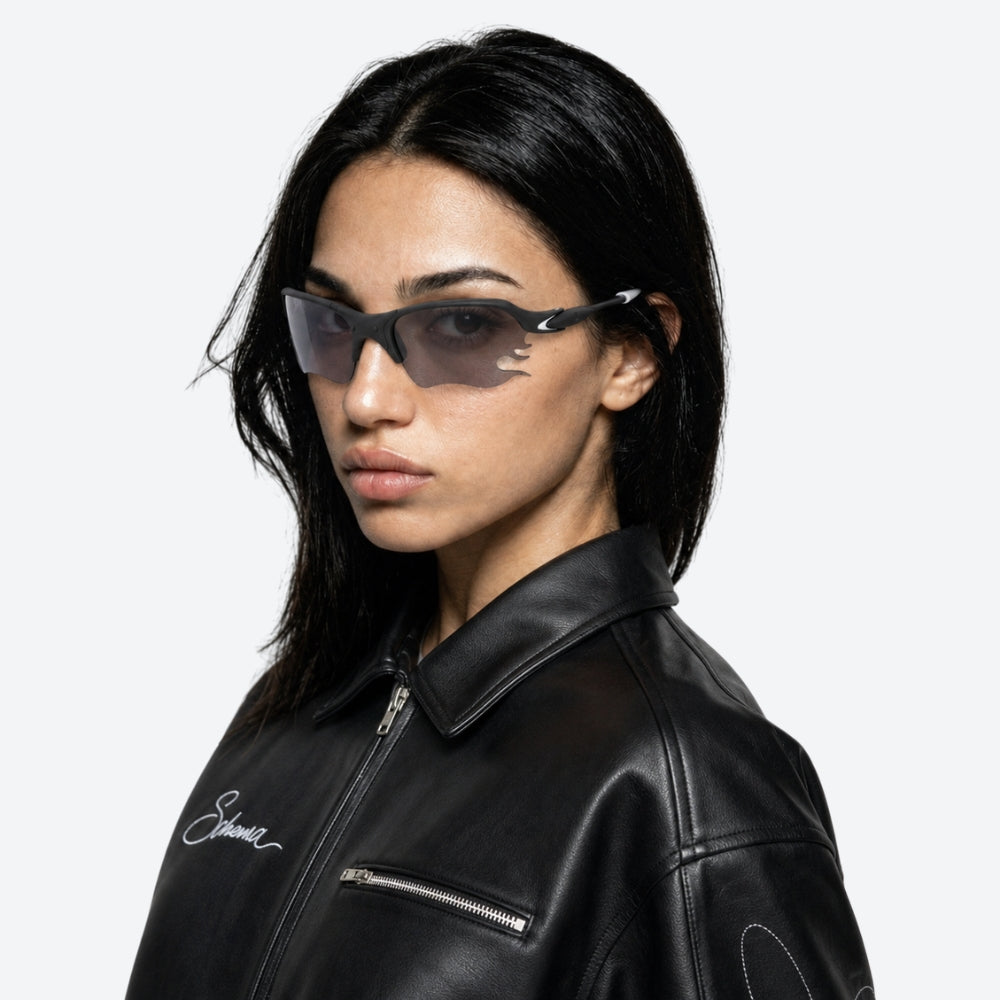 Person wearing a black and White VYSER sunglasses with dark lenses on a white background