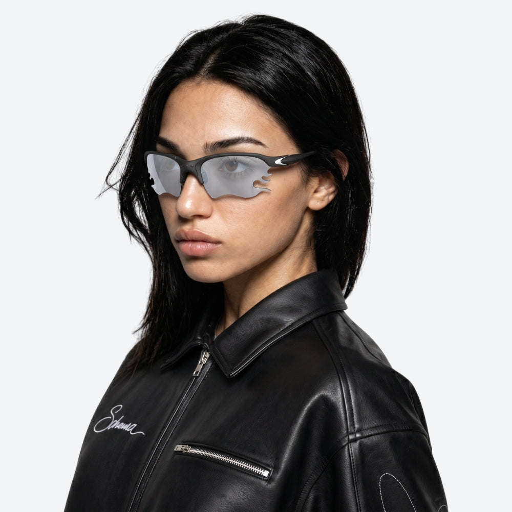 Person wearing a black and White VYSER sunglasses with dark lenses on a white background