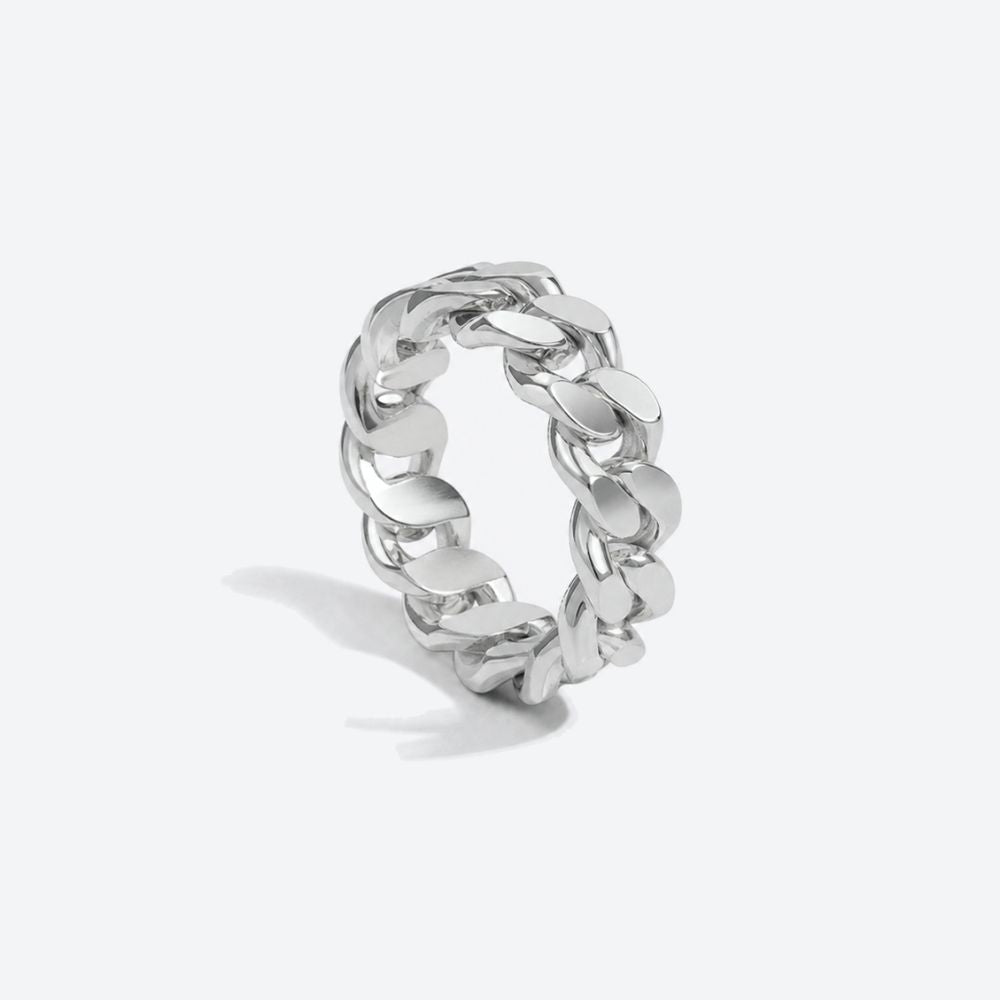 A polished silver-tone chunky curb link ring standing upright on a light gray background with a soft shadow.