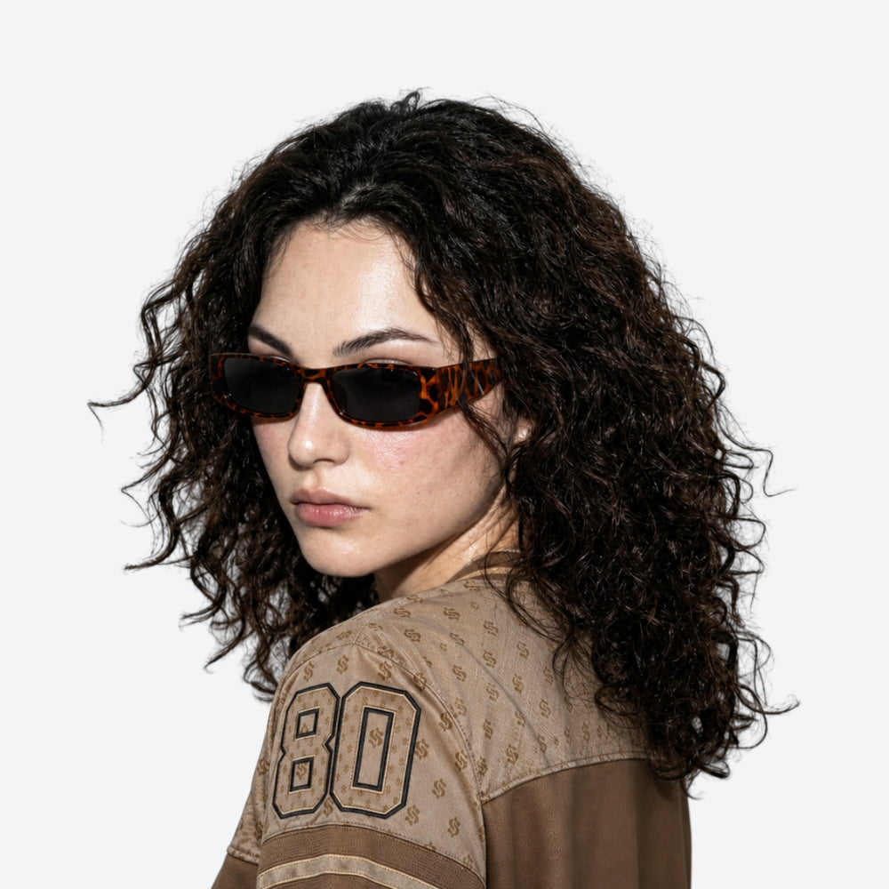 Woman wearing VYSER Sunglasses with leopard print frame on a white background