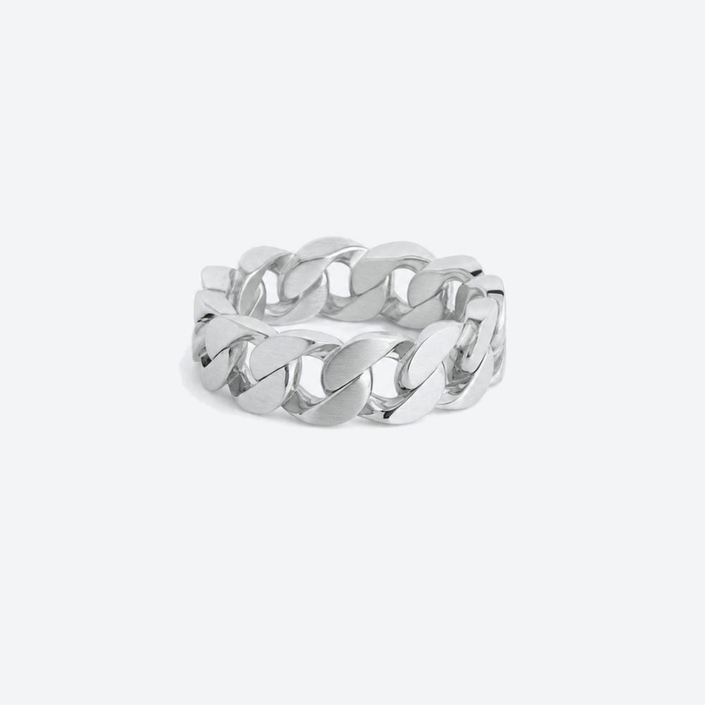 A polished silver-tone chunky curb link ring standing upright on a light gray background with a soft shadow.