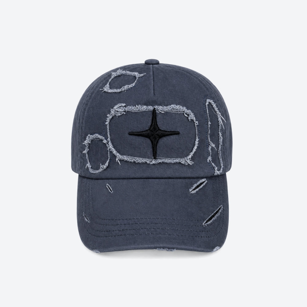 A distressed baseball cap in a washed navy blue color, featuring a black embroidered star inside a distressed white rectangular outline on the front, with additional frayed distressing on the brim and crown.