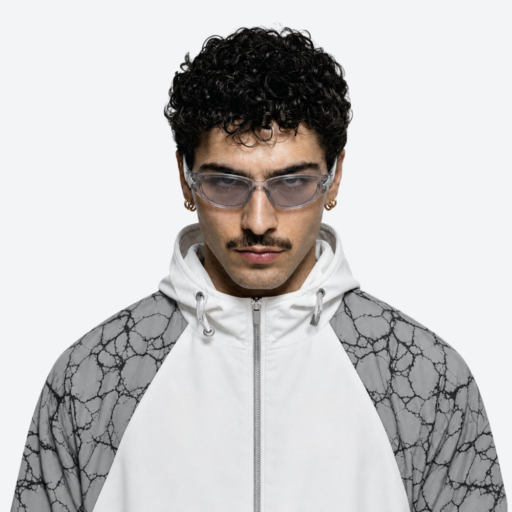 Person wearing a white hoodie with VYSER Sunglasses with clear lenses and decorative frame on a white background