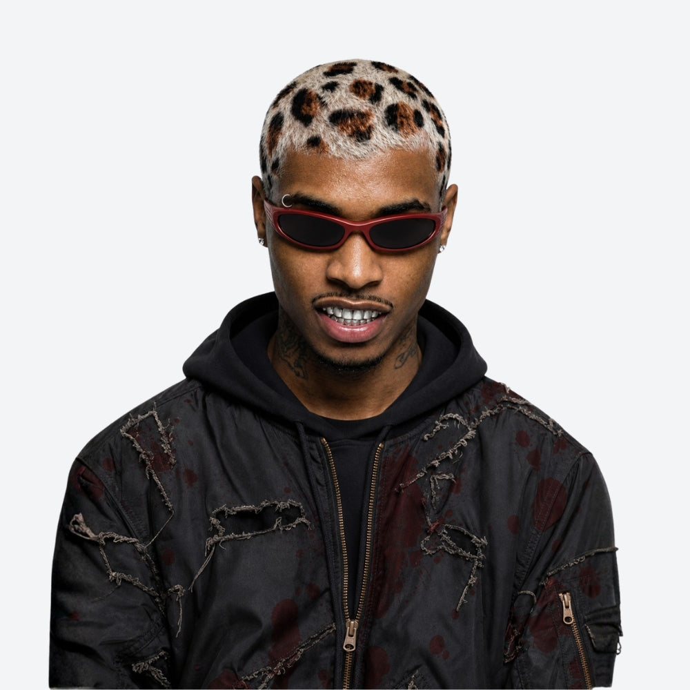 Person wearing a red VYSER Red sunglasses with dark lenses on a white background