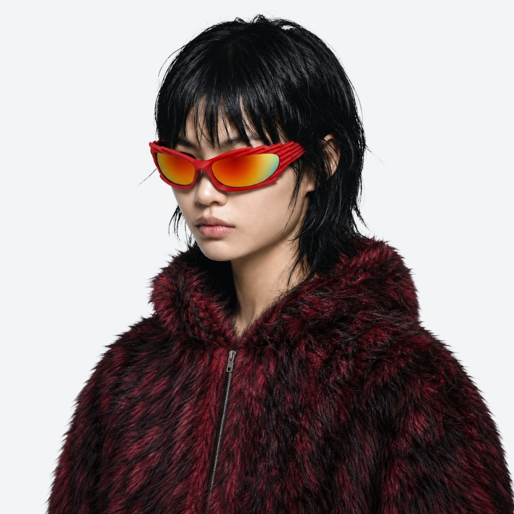 Person wearing a red fur coat and reflective VYSER Red sunglasses with unique frame design on a white background