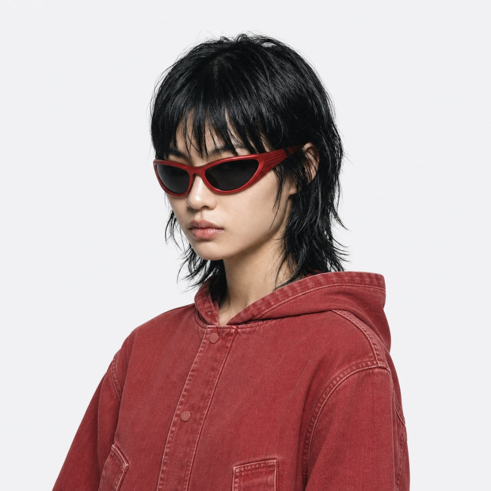 Person wearing red VYSER Red sunglasses with dark lenses on a white background