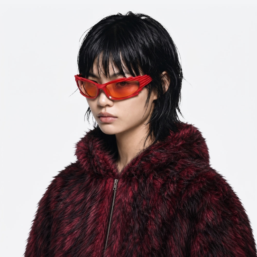 Person wearing a red fur coat and reflective VYSER Red sunglasses with unique frame design on a white background