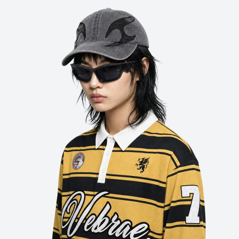 Person wearing a yellow and black striped shirt with 'Vibrant' branding, gray cap, and VYSER Black sunglasses with a white background