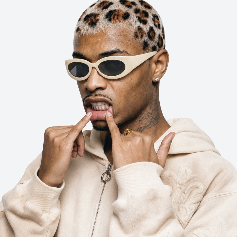 Person wearing VYSER Beige sunglasses with gray lenses on a white background