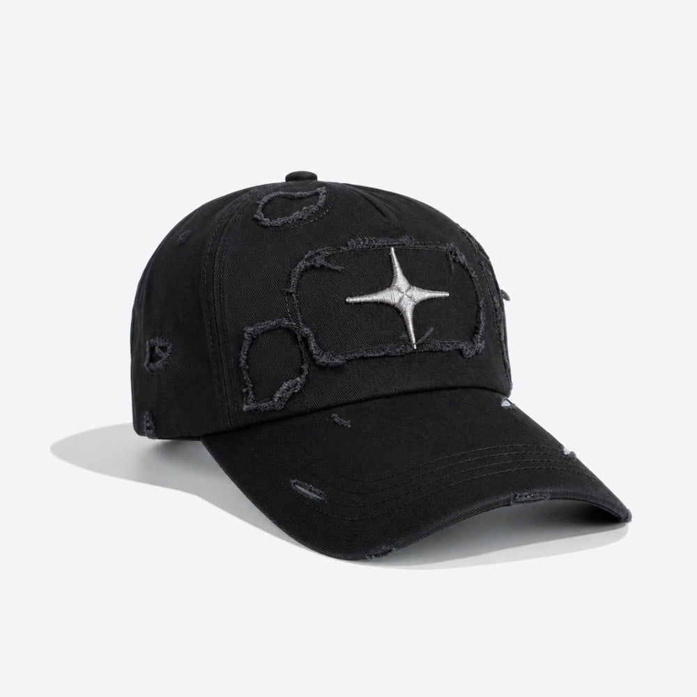A black distressed baseball cap with a silver embroidered four-pointed star on the front, set against a plain light gray background.