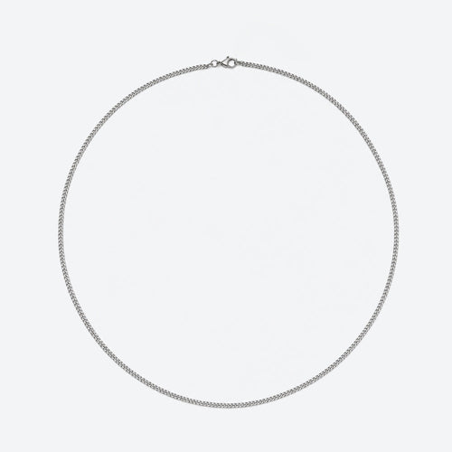 SILVER. A silver Cuban chain necklace with a small lobster clasp, displayed in a circular shape against a plain light gray background.