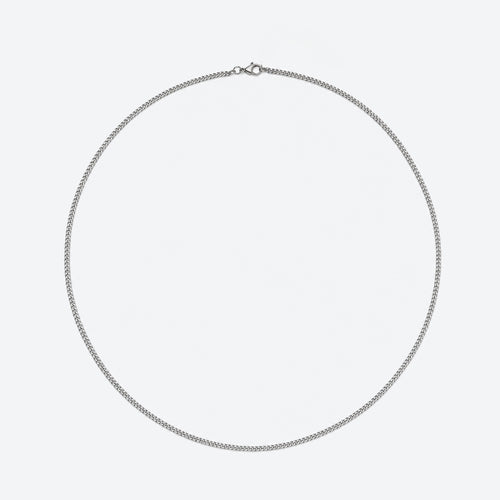 A silver chain necklace with a small lobster clasp, displayed in a circular shape against a plain light gray background.