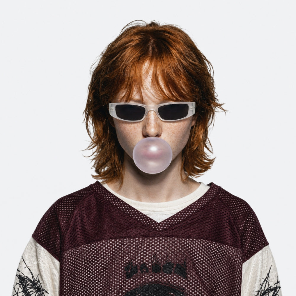 Person blowing a bubble with gum wearing VYSER White sunglasses with dark lenses on a white background