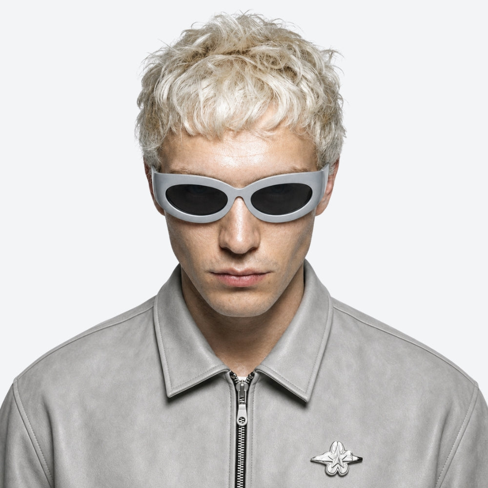 Person wearing a gray jacket with a brand logo and VYSER Silver sunglasses with dark lenses on a white background