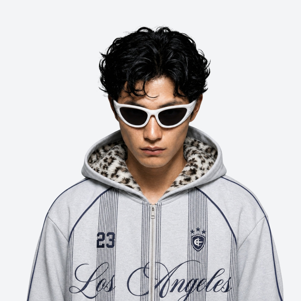 Person wearing a gray hoodie with VYSER White sunglasses with dark lenses on a white background