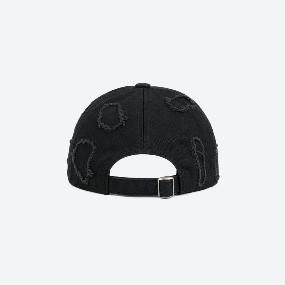 A black baseball cap shown from the back, featuring distressed ripped details and a black adjustable strap with a silver metal buckle, set against a plain light gray background.