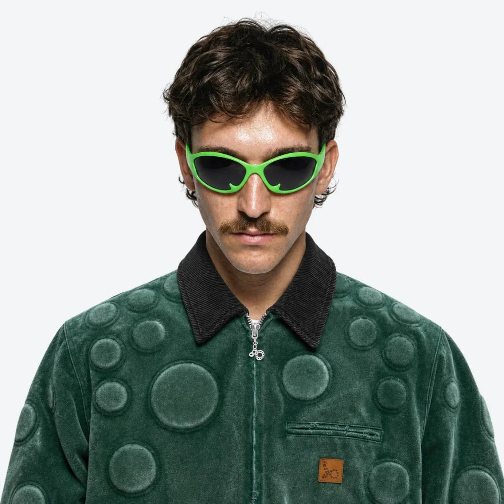 Person wearing VYSER neon green retro sunglasses with dark lenses, bold streetwear style for sunny days.
