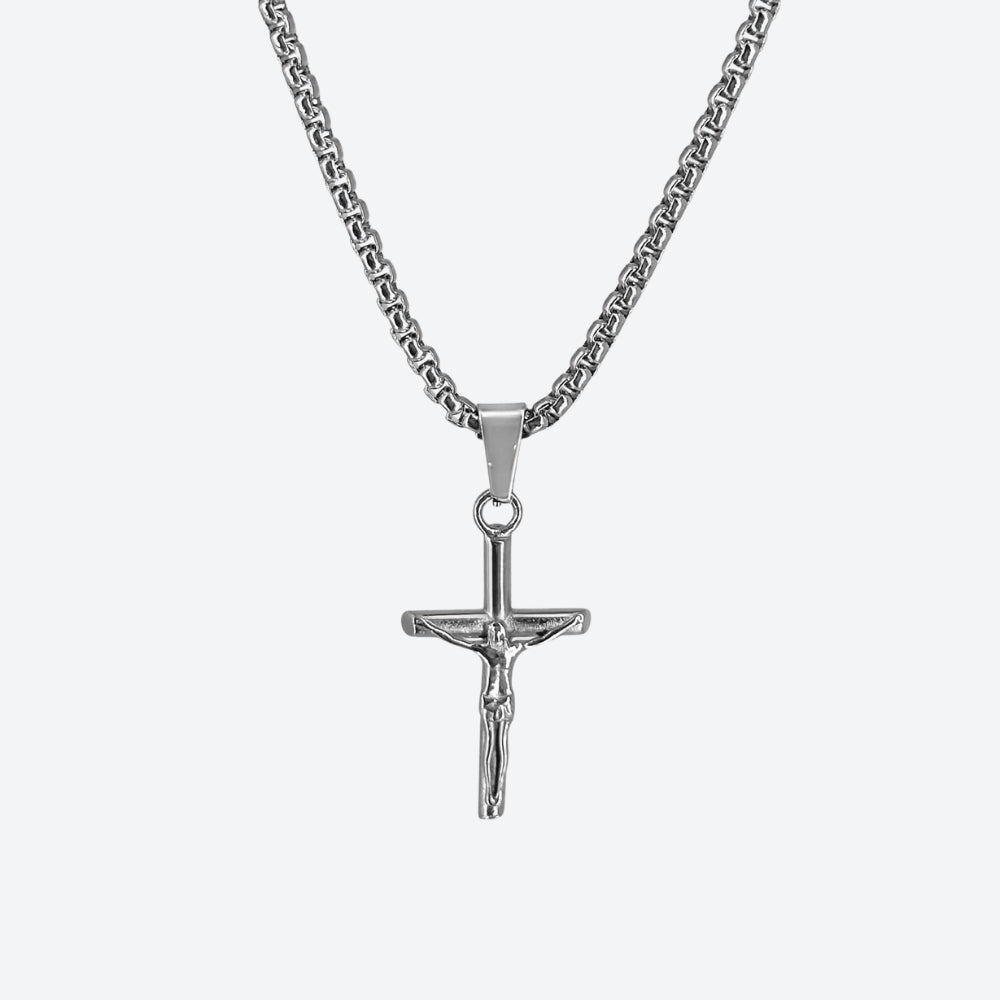 SILVER. A silver crucifix pendant necklace on a matching silver box chain, on a light gray background.