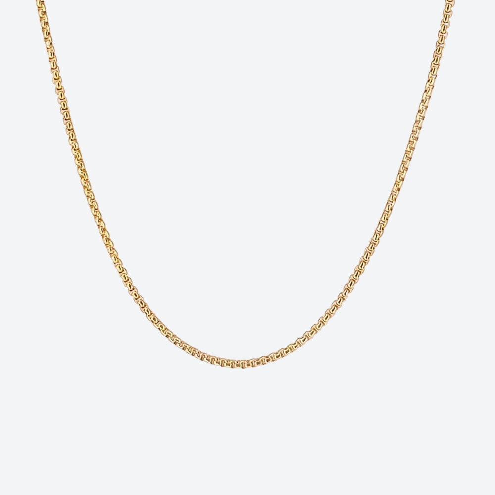 GOLD. A gold-toned box chain necklace displayed against a solid light gray background.