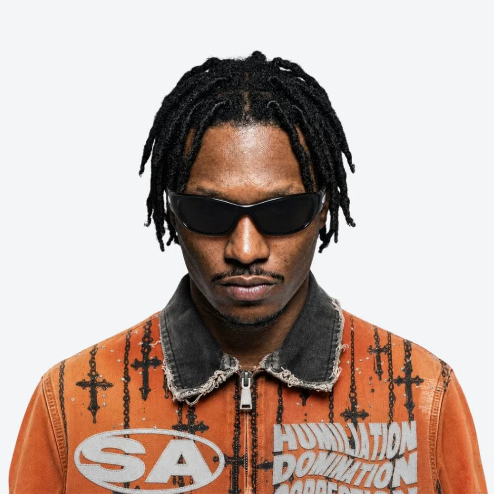 A man with black dreadlocks and VYSER black sporty sunglasses with sleek frame and dark lenses, modern streetwear style.