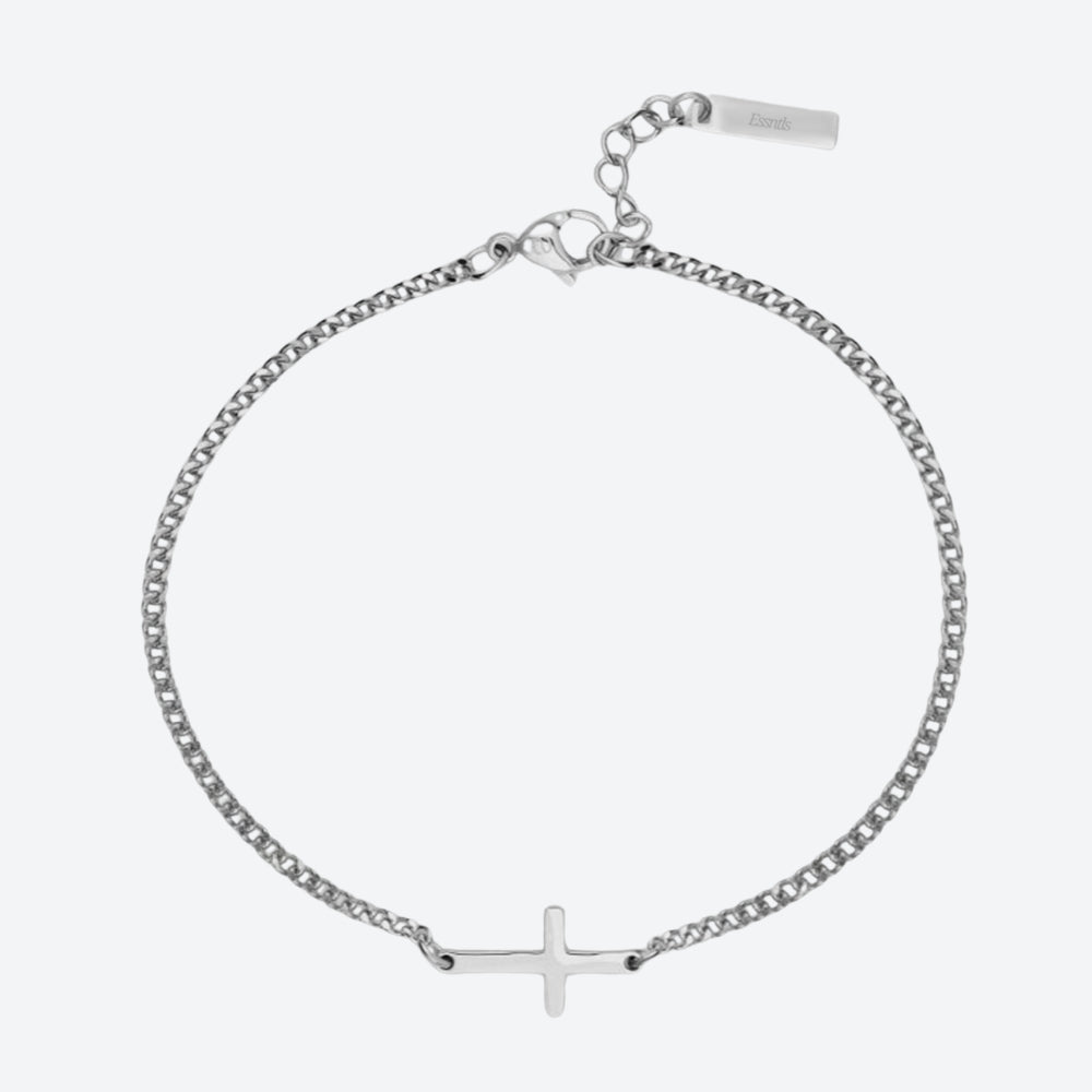 A silver chain bracelet with a small cross pendant at the bottom center, shown on a light gray background. The bracelet has an adjustable clasp with a tag engraved with the brand name 'Luna'.