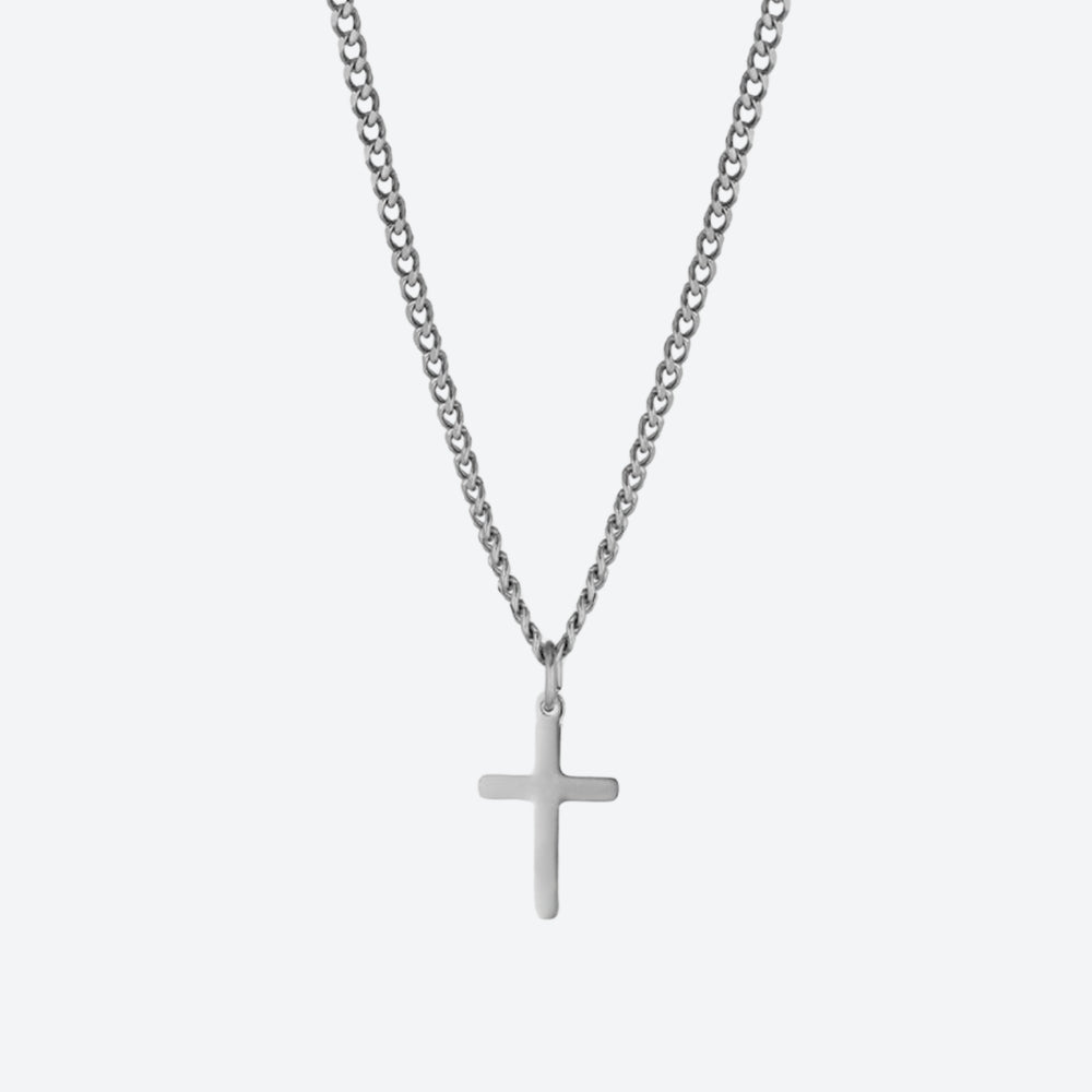 A silver cross pendant necklace on a matching silver curb chain, shown against a light gray background.