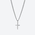 A silver cross pendant necklace on a matching silver curb chain, shown against a light gray background.