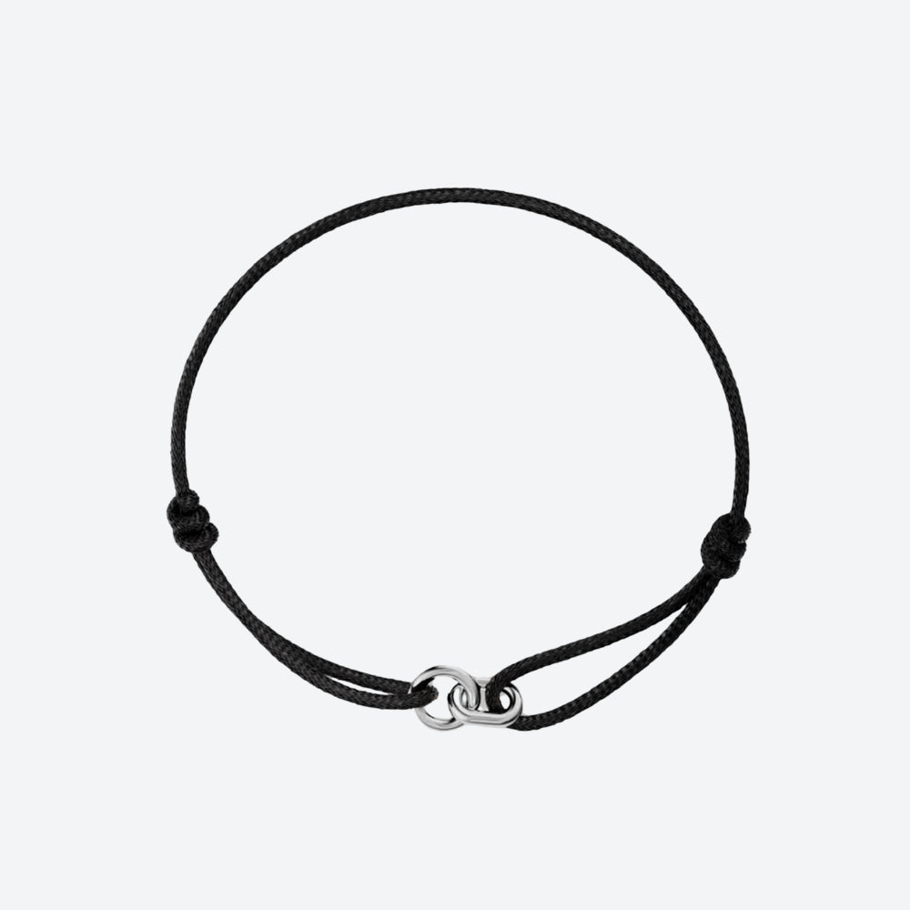 A black adjustable cord bracelet with a polished silver-toned infinity link clasp, displayed on a clean light gray background.