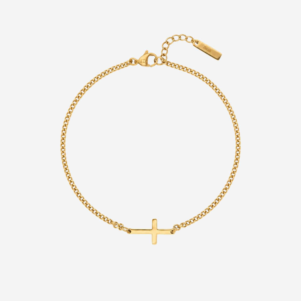 GOLD. A gold chain bracelet with a small flat cross pendant, on a clean light gray background.