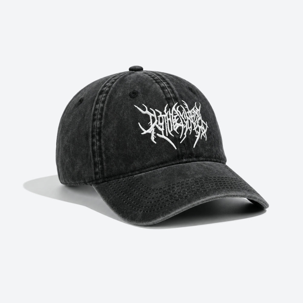 A washed black baseball cap with a white embroidered stylized logo on the front, displayed on a clean white background with a soft shadow.