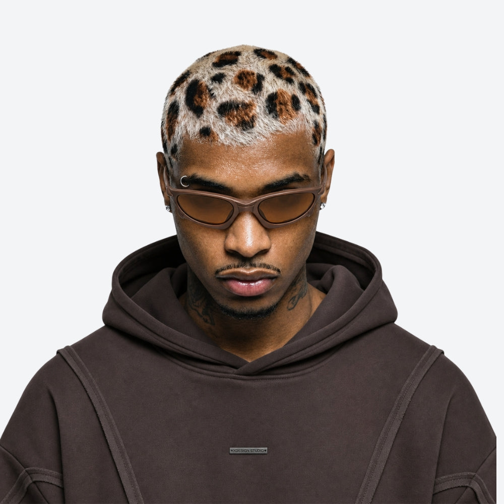 Man wearing a brown hoodie and VYSER Brown sunglasses with brown lenses on a white background