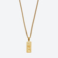 A gold-toned chain necklace with a rectangular pendant designed to look like a U.S.