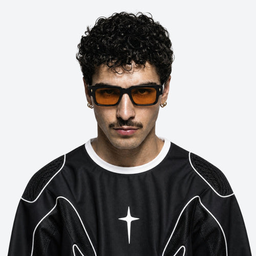 Man wearing VYSER Black sunglasses with orange lenses on a white background